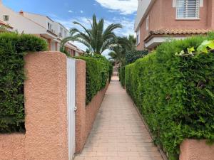 ceglany płot z białymi drzwiami obok chodnika w obiekcie Bungalow in San Juan Playa w mieście Benimagrell