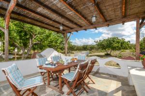 a wooden table and chairs under a wooden pergola at Katerinas villa in Agia Anna Naxos