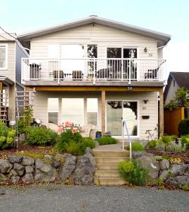 a white house with a porch and a balcony at AnnArthur Guest House in Nanaimo