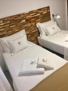 two beds in a room with white sheets and pillows at Centro Histórico Mezquita Judería La Preferida in Córdoba