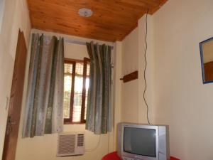 TV in einem Zimmer mit Fenster in der Unterkunft Hosteria Las Piedras in Puerto Iguazú