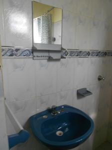 La salle de bains est pourvue d'un lavabo bleu et d'un miroir. dans l'établissement Hosteria Las Piedras, à Puerto Iguazú