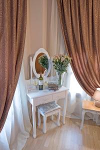 a table with a vase of flowers and a mirror at Athina house in Rhodes Town +33 photos