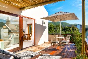 a patio with a table and an umbrella at Founders Keepers - Leisure Isle in Knysna