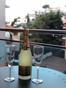 a bottle of wine and two glasses on a table at Apartament Lloret de Mar with terrace in Lloret de Mar