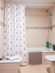 a bathroom with a shower curtain with anchors on it at Apartament Lloret de Mar with terrace in Lloret de Mar