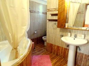 La salle de bains est pourvue d'un lavabo, d'une baignoire et de toilettes. dans l'établissement Cozy apartment in Paradisi, à Paradeísion