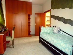 a bedroom with a bed and a desk and cabinets at Cozy apartment in Paradisi in Paradeísion