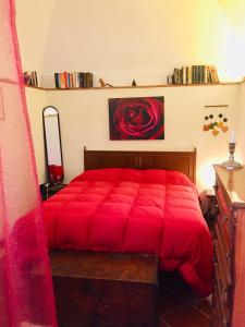 a bedroom with a red bed with a red blanket at LaTanaSegreta in Monterotondo