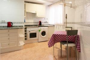 kuchnia ze stołem i pralką w obiekcie Apartamento w Santa Susanna