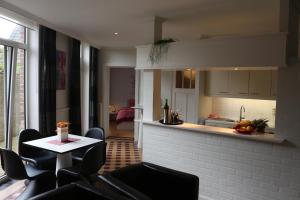 a living room with a table and chairs and a kitchen at Loft at Bruges in Varsenare