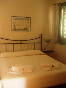 a bedroom with a bed with two towels on it at La Plaza Residence Levanzo in Levanzo