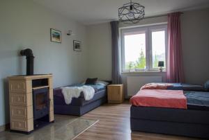 ein Schlafzimmer mit zwei Betten und einem Fernseher in der Unterkunft Pokoje Gościnne 4 Pory Roku in Klimkówka
