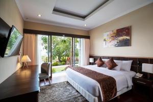 a hotel room with a bed and a large window at Semabu Hills Hotel Nusa Penida in Nusa Penida
