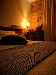 ein Schlafzimmer mit einem Bett und einer Lampe in einem Zimmer in der Unterkunft Aljama - Downtown B&B in Agrigento