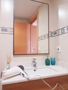 uma casa de banho com um lavatório e um espelho grande em Apartament Lloret de Mar with terrace em Lloret de Mar
