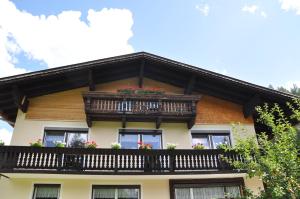 a house with a balcony with flowers on it at Haus Freispitzblick in Bach