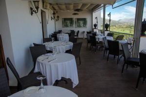a dining room with tables and chairs with white tablecloths at Hotel Montelirio in Ronda