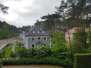 a white house with a gray roof at Willa Reverans in Borne Sulinowo