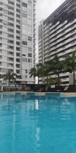 a large blue swimming pool in front of tall buildings at LUXURY APARTMENT PUERTO SANTA ANA GUAYAQUIL in Guayaquil