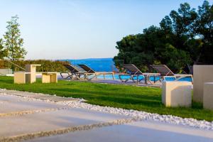 una fila de bancos en un parque con el océano en el fondo en Bel Etage Amora Luxury Seaview Apartment with pool en Split