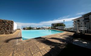 a large swimming pool on a patio at Eden Appartement, T2 49m2, 4 pers vue mer, piscine in Saint-Gilles les Bains
