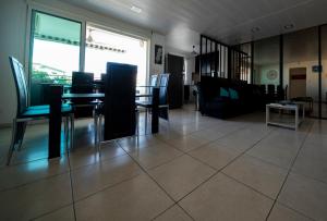 a dining room with a table and chairs on a tile floor at Eden Appartement, T2 49m2, 4 pers vue mer, piscine in Saint-Gilles les Bains