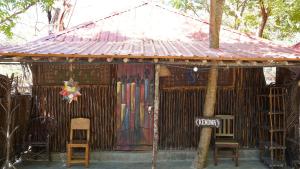 uma pequena cabana com cadeiras e um cartaz em Soul Breeze Backpackers Diani em Diani Beach