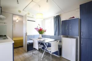 a kitchen with blue cabinets and a table and chairs at Baia Di Campi in Vieste