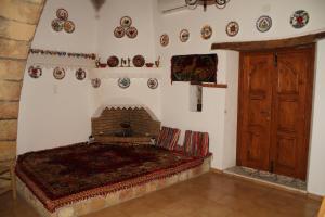 アルハンゲロスにあるKellas traditional houseのベッドルーム1室(ベッド1台、暖炉、壁に皿付)