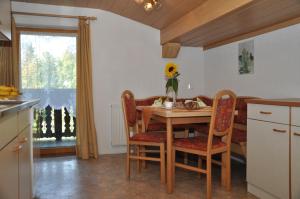 una cucina con tavolo in legno, sedie e tavolo di Haus Freispitzblick a Bach