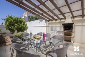a patio with a glass table and chairs and a fireplace at Villa Maresia in Patroves