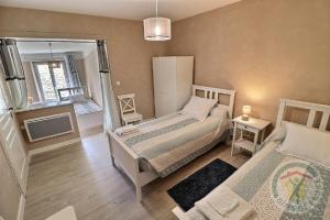 a small bedroom with two beds and a mirror at Gîte de l'Eclotine in Saint-Théodorit