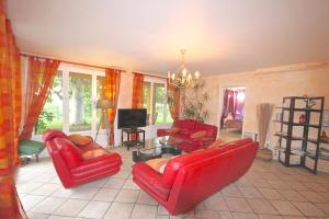 a living room with red furniture and a chandelier at Gîte des Orgues de la Sybille Eucalyptus in Ille-sur-Têt