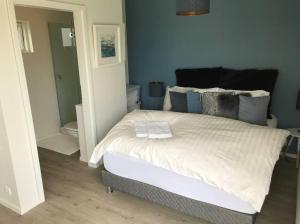 - une chambre avec un grand lit aux murs bleus dans l'établissement Dalabyggd Cottages - Romantic stay by the Secret Lagoon, à Fludir
