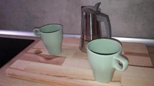 due tazze sedute su un tagliere con uno spremiagrumi di Grifo Apartment a Grosseto
