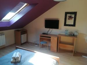 a bedroom with a bed and a desk and a tv at Stary Drahim in Czaplinek