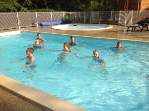 a group of children swimming in a swimming pool at Camping Le Pont d'Allagnon in Lempdes sur Allagnon