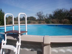 a chair sitting on the edge of a swimming pool at Le Cormier in Obterre