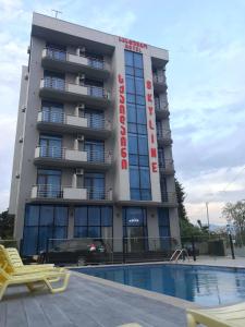 a hotel with a swimming pool in front of a building at Hotel Skyline Batumi in Batumi