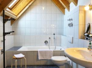 a bathroom with a tub and a toilet and a sink at 4-Star Holiday House Rösslewiese in Hinterzarten