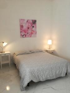 a bedroom with a bed and two tables with lamps at Casa Margherita piano terra in Mondragone