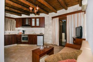 eine Küche mit einem Sofa und einem TV in einem Zimmer in der Unterkunft Ariadni Apartments in Sfinárion