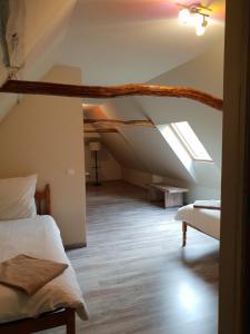 a attic room with a bed and a couch at Bed In Bellongue in Aucazein