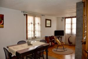 a dining room with a table and chairs and a television at Au Merlenchanteur in Schiltigheim