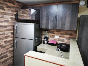 cocina con nevera y barra con licuadora en Apartamento suite para parejas o ejecutivos, en Manta