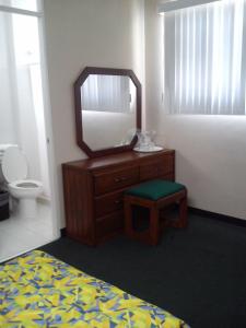 Dormitorio con tocador con espejo y taburete en Fiesta Versalles, en Monterrey