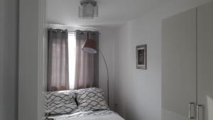 een slaapkamer met een lamp, een bed en een raam bij La Dolce Vita2 in Dziwnówek