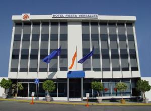 a hotel with flags in front of a building at Fiesta Versalles in Monterrey