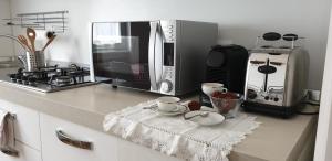 - un comptoir de cuisine avec un four micro-ondes et 2 tasses à café dans l'établissement La Turr de Mezz- Bellagio LCA, à Bellagio